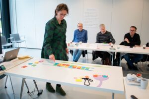 een persoon met kaartjes aan het schuiven met mensen op de achtergrond
